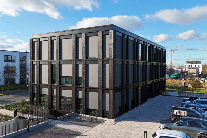 Moderne Wohnanlage in monochromer Darstellung, mit Balkonen und Garagenzugang.