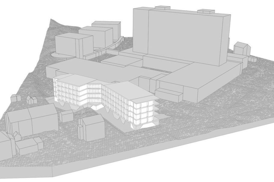 Mehrstöckiges Wohngebäude mit Grünfläche und Straßenbeschilderung im Vordergrund.